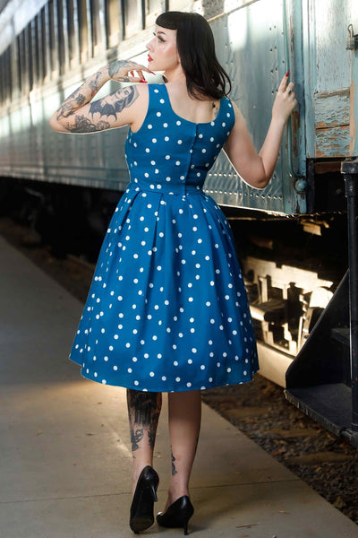 Back view of model wearing Polka Dot Swing Dress Peacock Blue & White