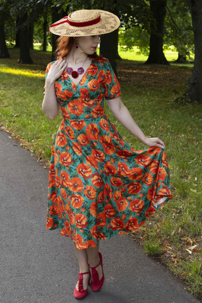 A lady wearing a Julia Poppy Midi Dress In Teal