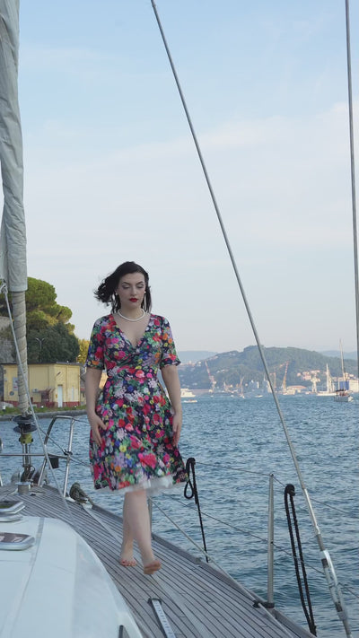 Video of a model wearing our Matilda Navy Blue Midnight Garden Floral Wrap Dress aboard a yacht.