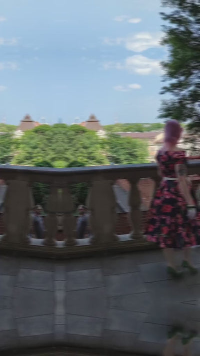 Video of woman wearing our V neck Lily dress, in navy blue, with pink tulips, with accessories