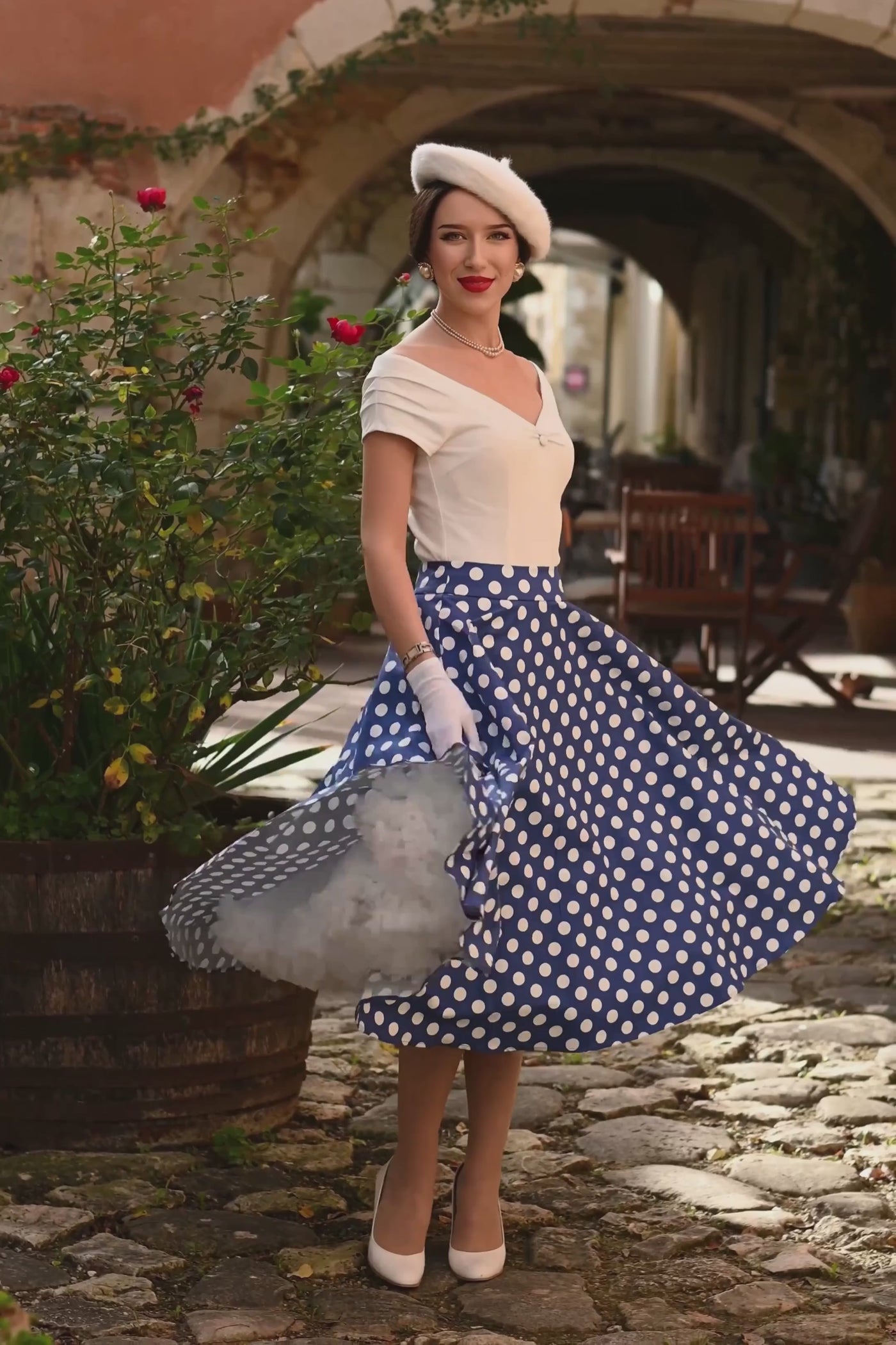 A model wearing a Maisie Navy Polka Dot Full Circle Midi Skirt