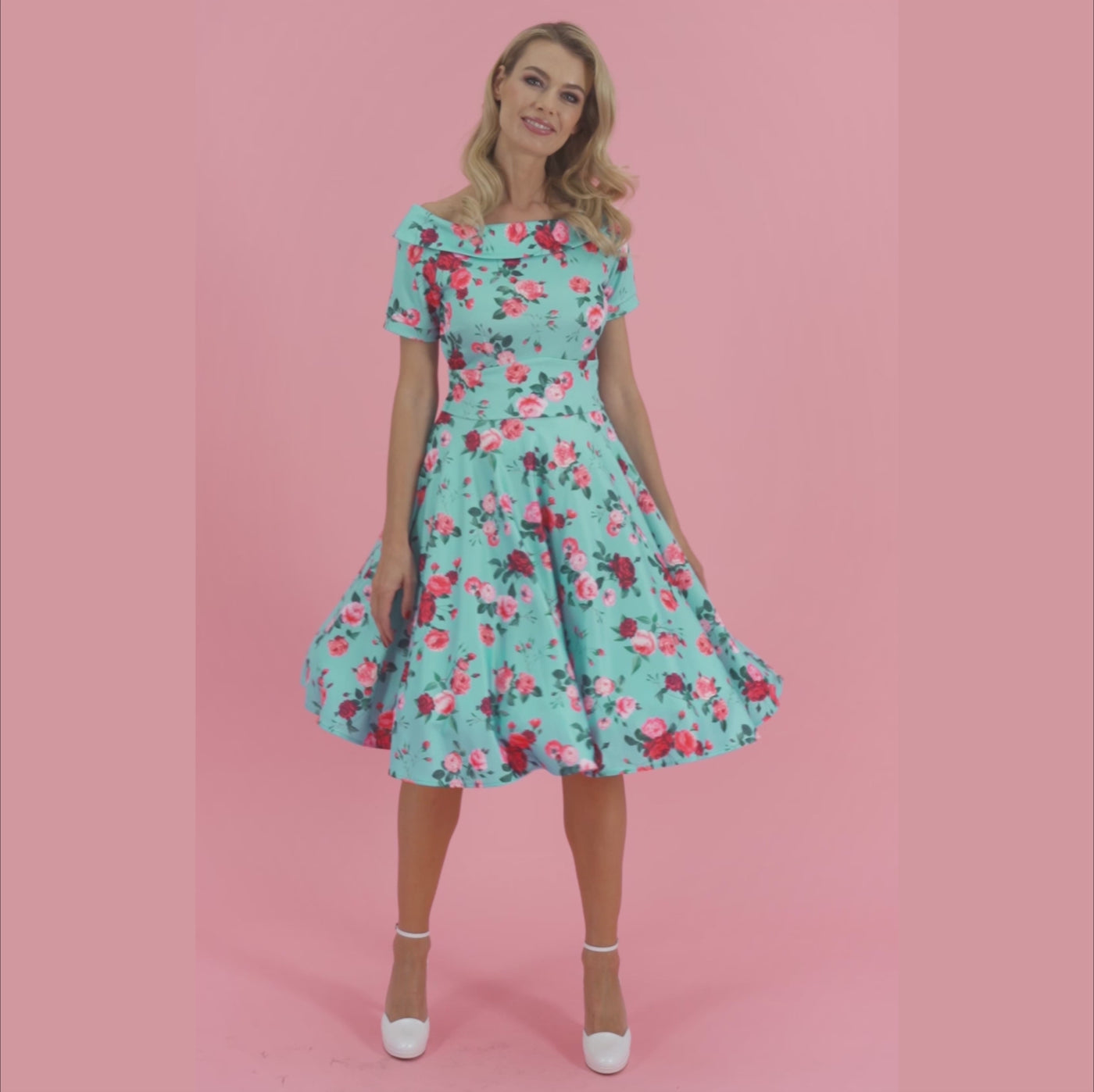 Video of a model twirling while wearing an aqua blue floral print dress.