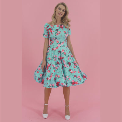 Video of a model twirling while wearing an aqua blue floral print dress.