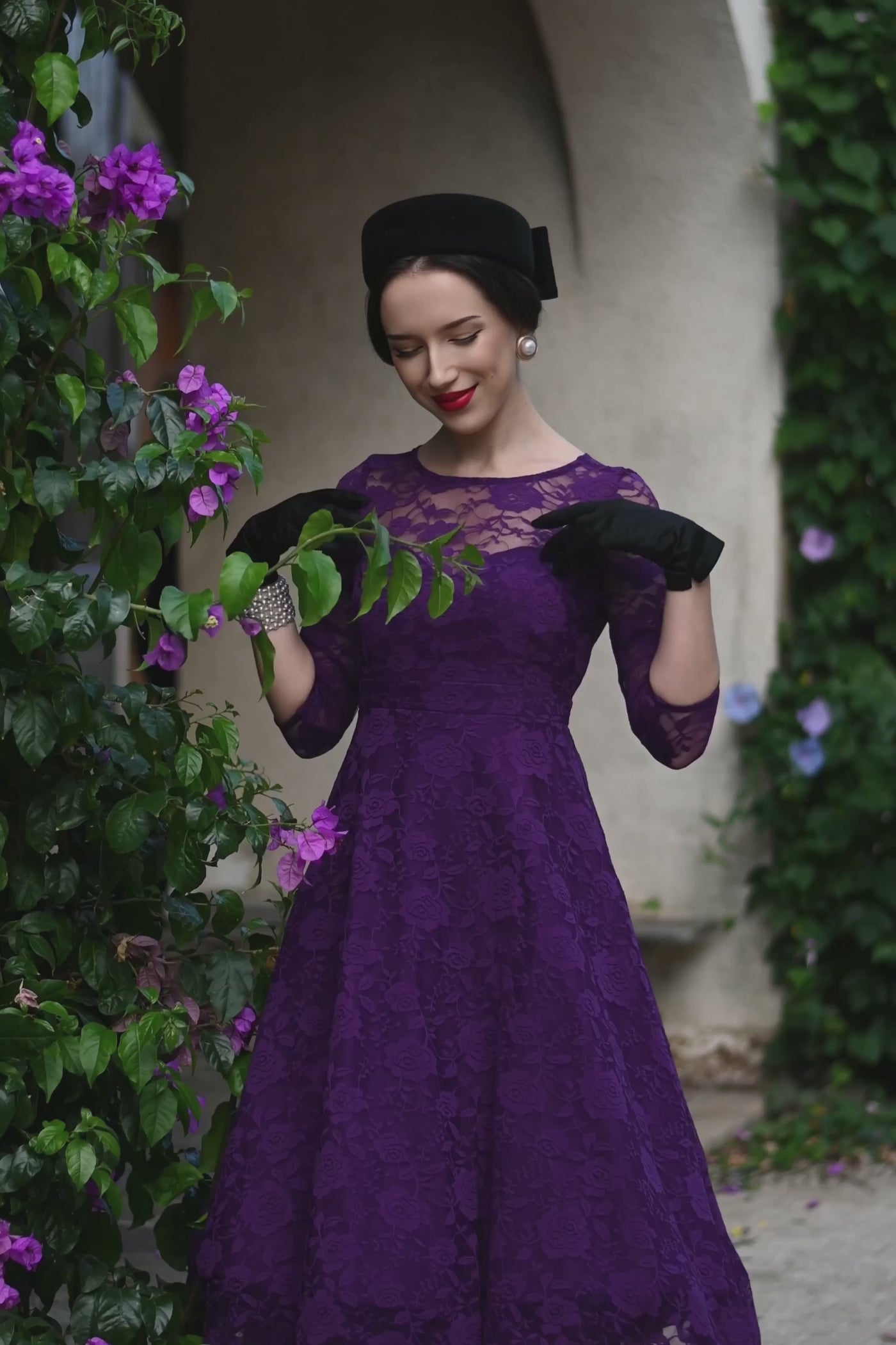 A video of a lady wearing a Madeline Long Sleeved Purple Lace Dress