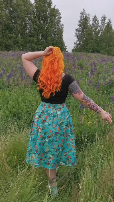 Video of a model in a Lavender field wearing a black plain blouse with  Green Skirt with Dinosaur print.