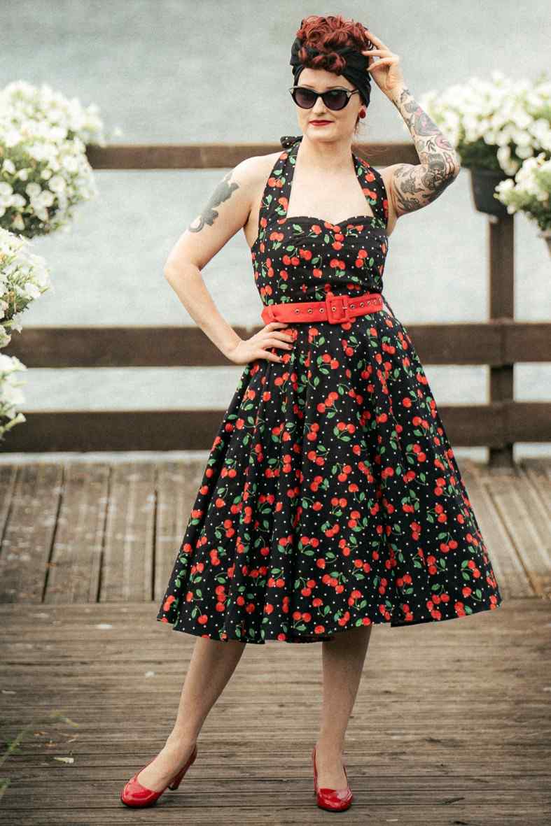 A woman wearing a Daisy Red Cherry Halter Dress In Black