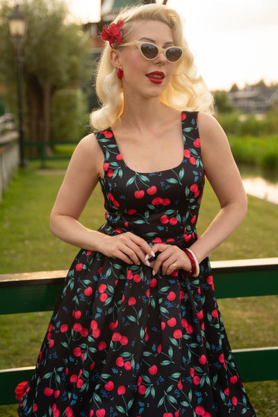 A model wearing a Red Cherry Pleated Circle Dress In Black
