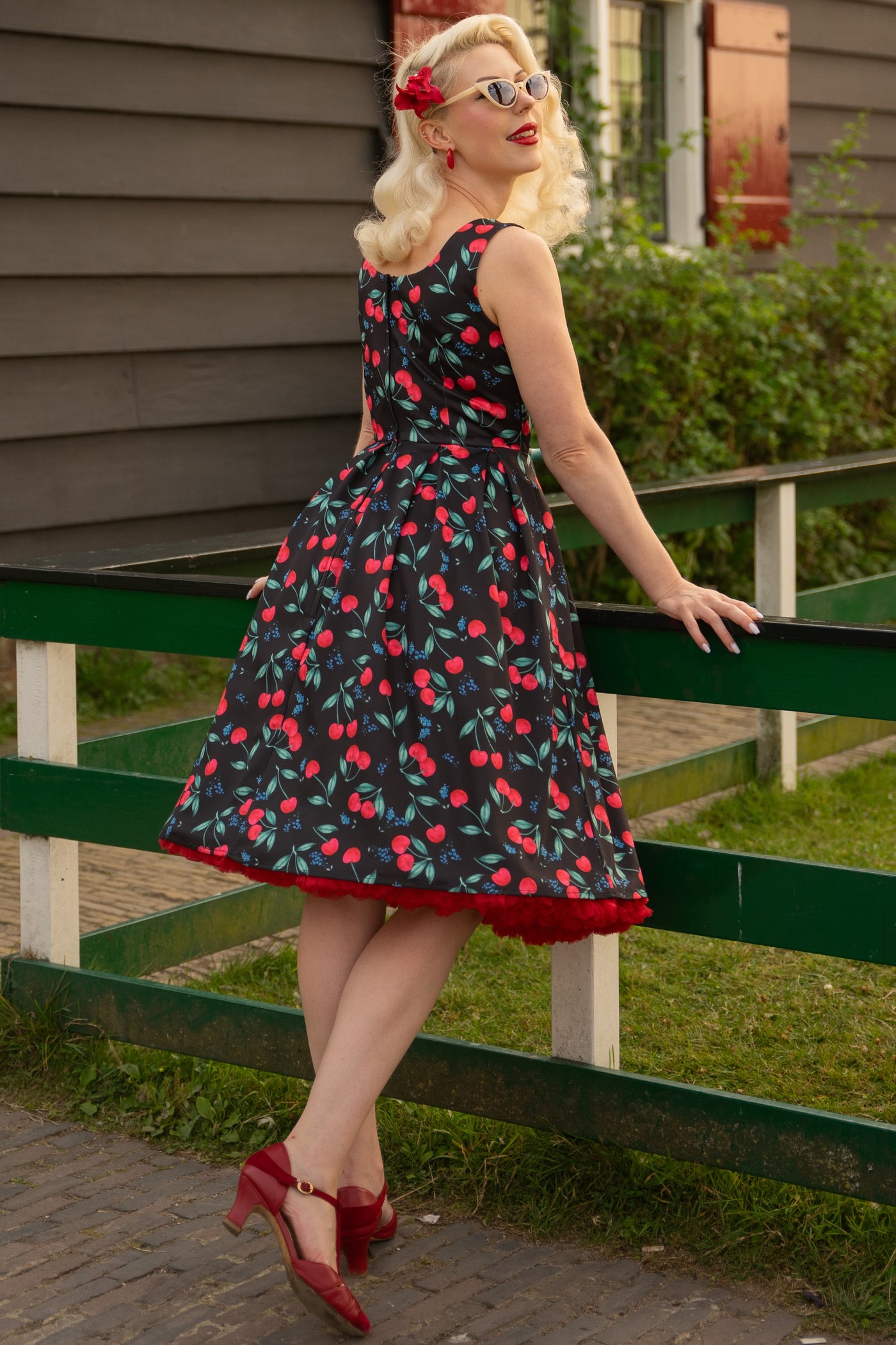 A model wearing a Red Cherry Pleated Circle Dress In Black