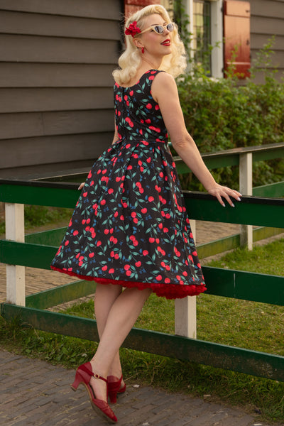 A model wearing a Red Cherry Pleated Circle Dress In Black