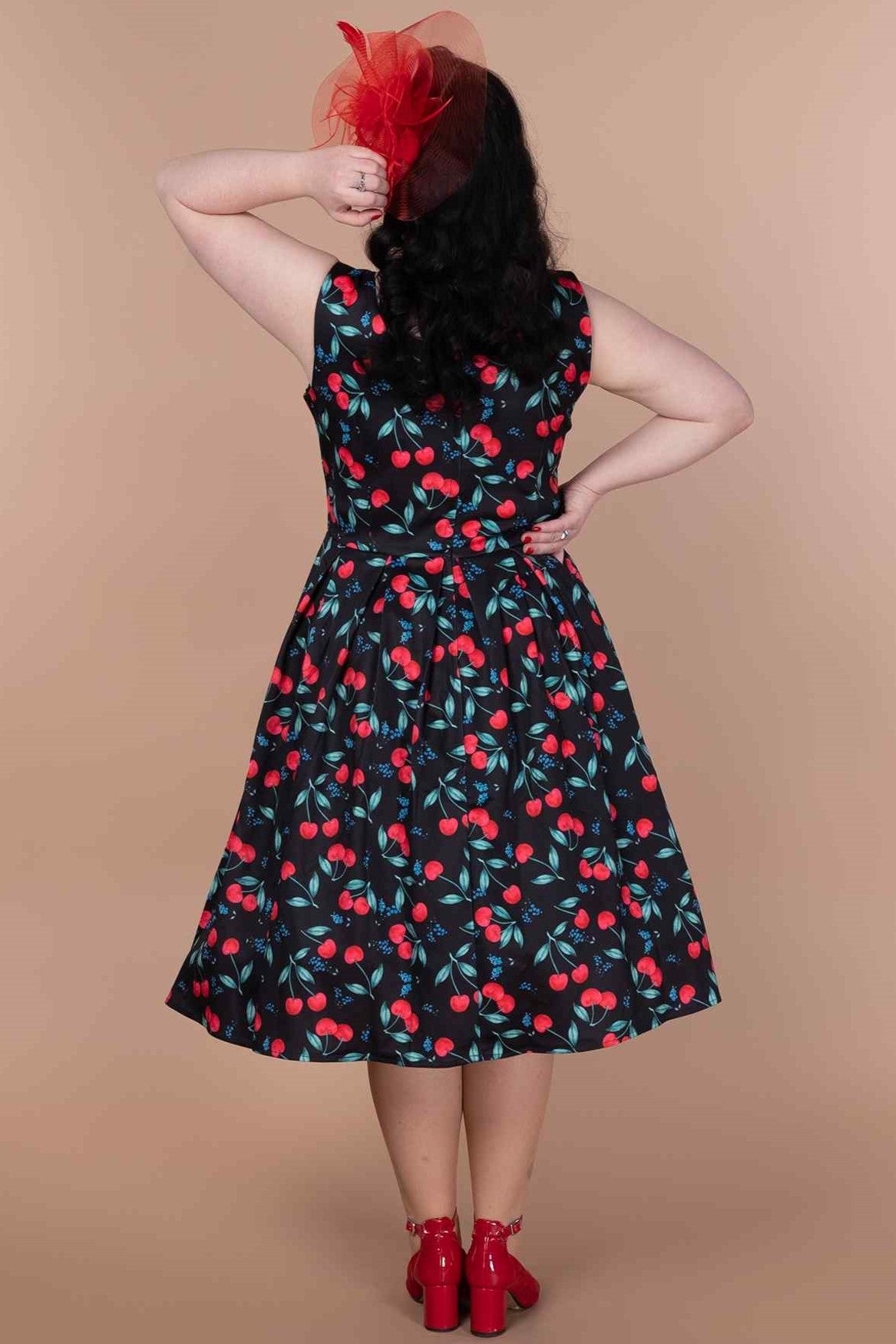 A model wearing a A model wearing a Red Cherry Pleated Circle Dress In Black