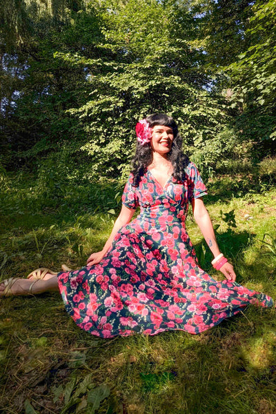 A model wearing Red Floral Midi Dress In Petrol Blue in the forest