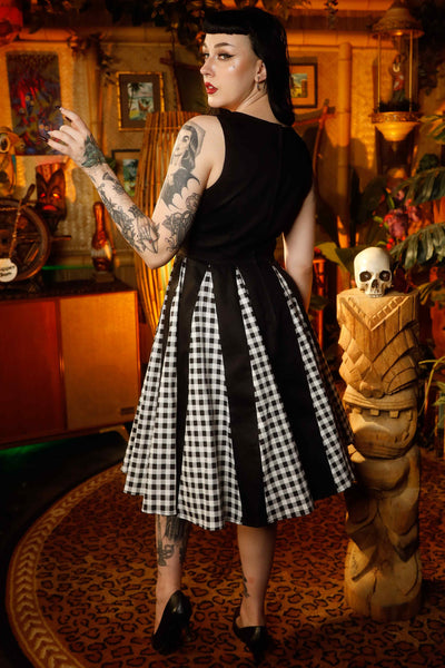 A model wearing a Retro Pleated Black Dress With Gingham Check