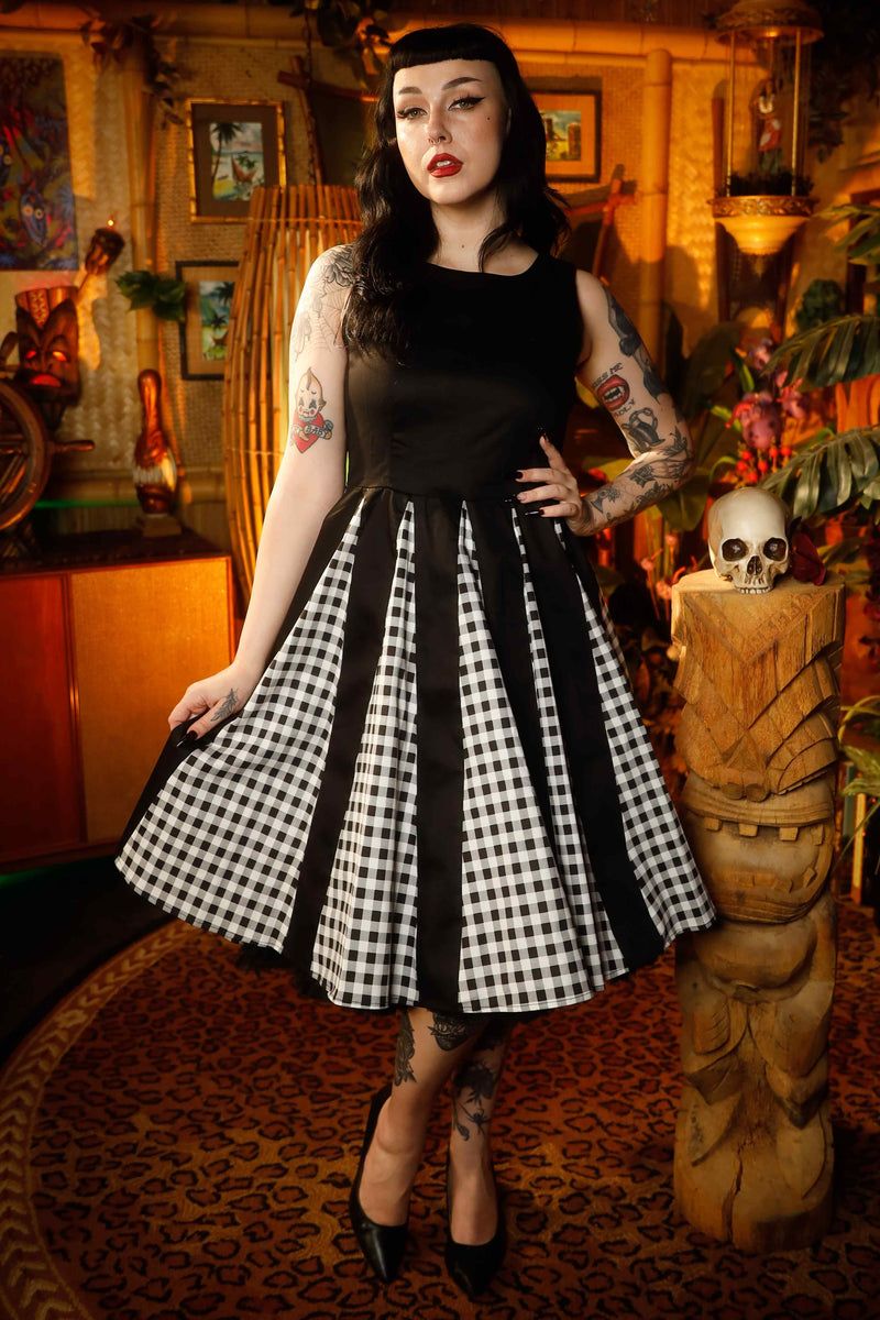 A model wearing a Retro Pleated Black Dress With Gingham Check