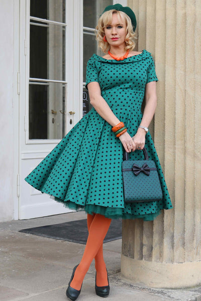 A lady wearing a Retro Polka Dot Swing Dress in Dark Green