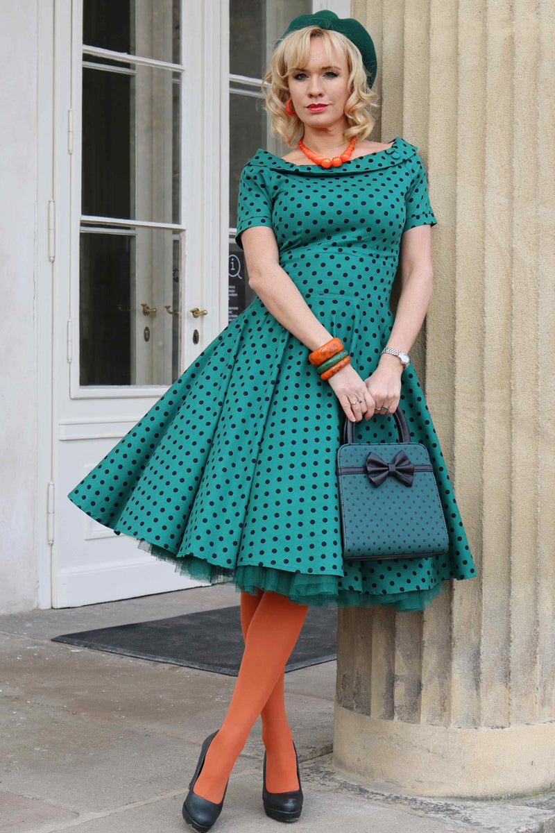 A lady wearing a Retro Polka Dot Swing Dress in Dark Green