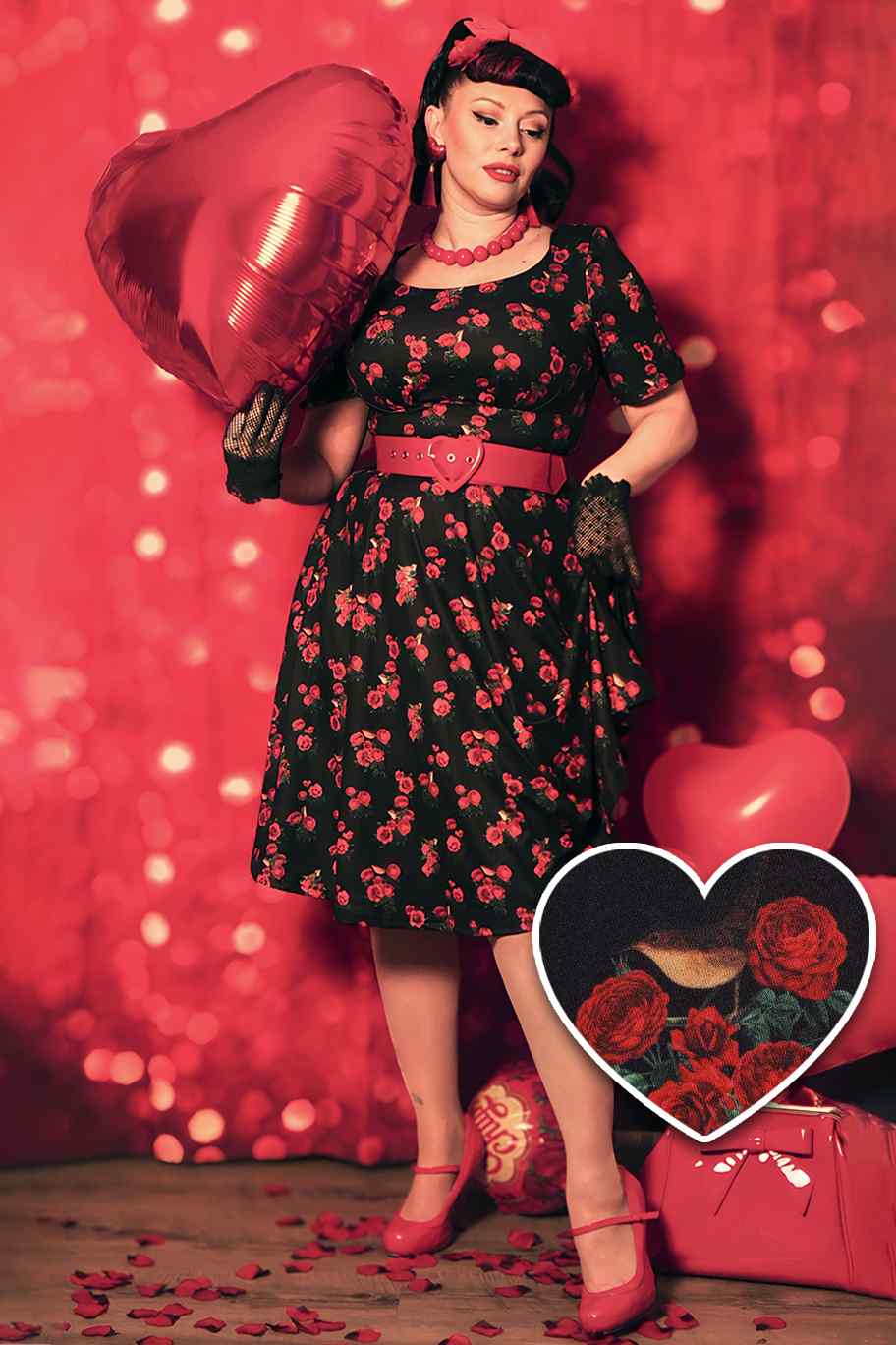 Customer wears our Brenda short sleeve dress in black red roses and birds print, with a heart balloon
