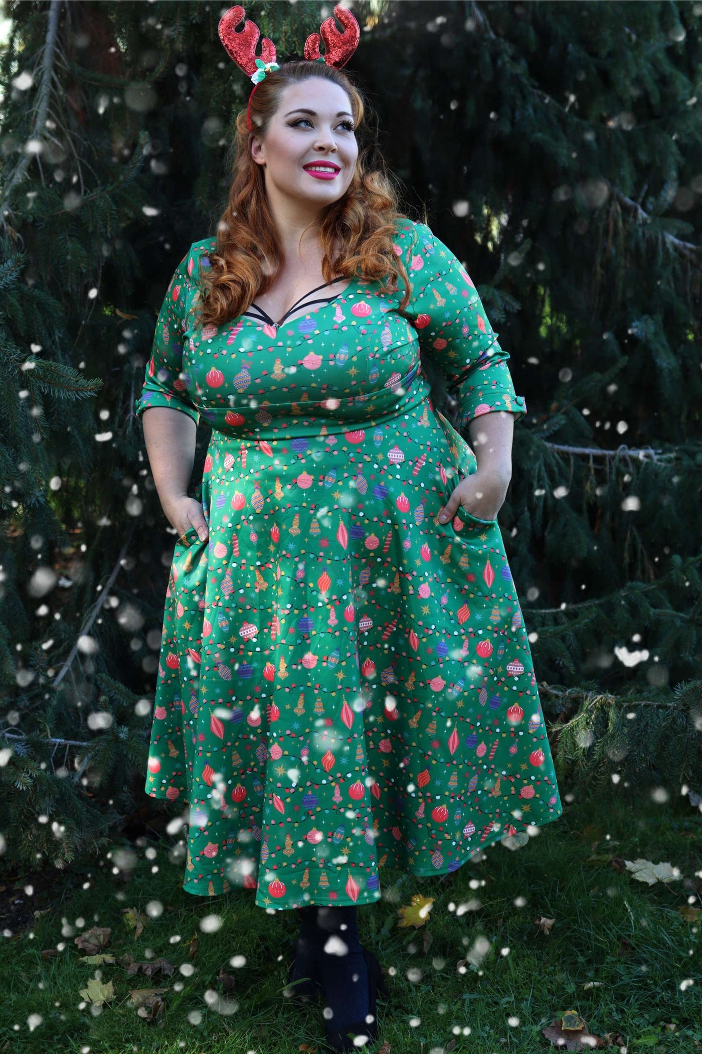 A woman wearing a Scarlette Christmas Tree Green Midi Dress