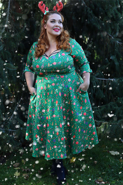 A woman wearing a Scarlette Christmas Tree Green Midi Dress