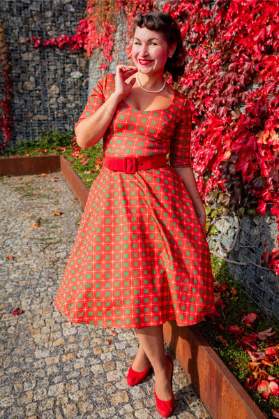A woman wearing a Scarlette Mistletoe Plaid Midi Dress