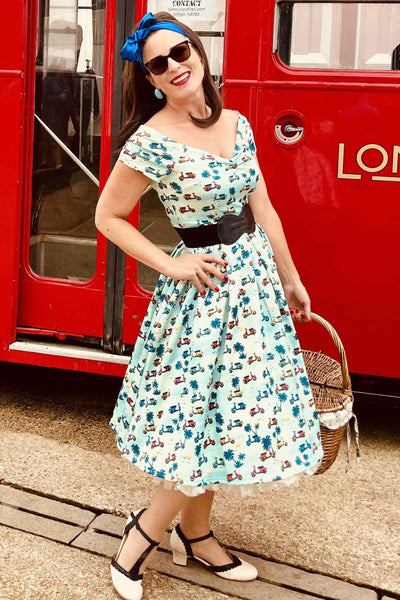 A lady wearing a Scooter Print Off Shoulder Dress in Turquoise Blue