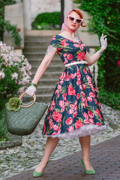 Woman posing in our Short Sleeved Pleated Lily Dress in Navy Blue/Pink Tulip print, with accessories