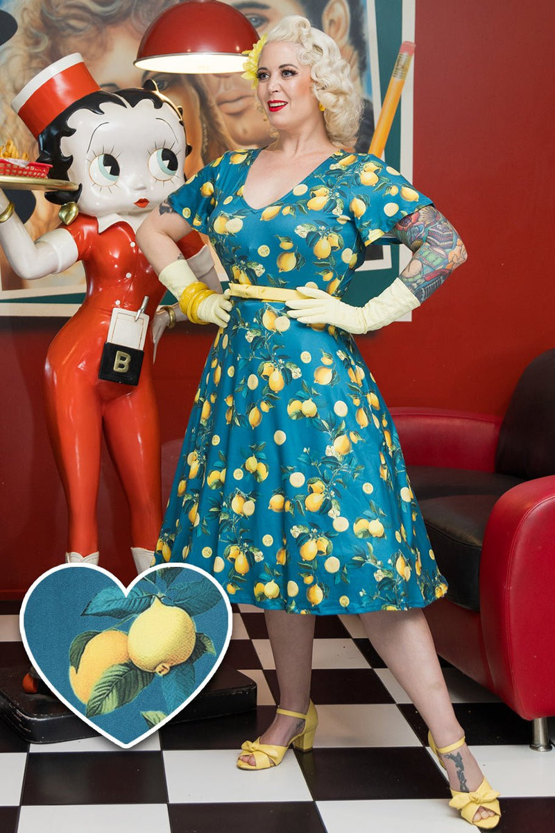 Model wearing Short Sleeved Tea Dress in Teal Blue Lemon Print