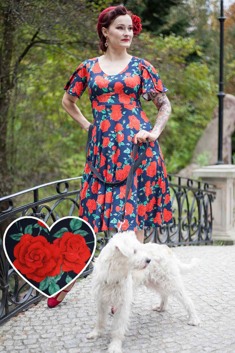 A model wearing a Sleeved Tea Dress in Navy Blue and Red Rose Print