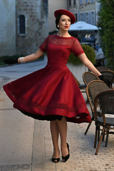 A charming model wearing a Tess Lace Sleeved Dress in Burgundy