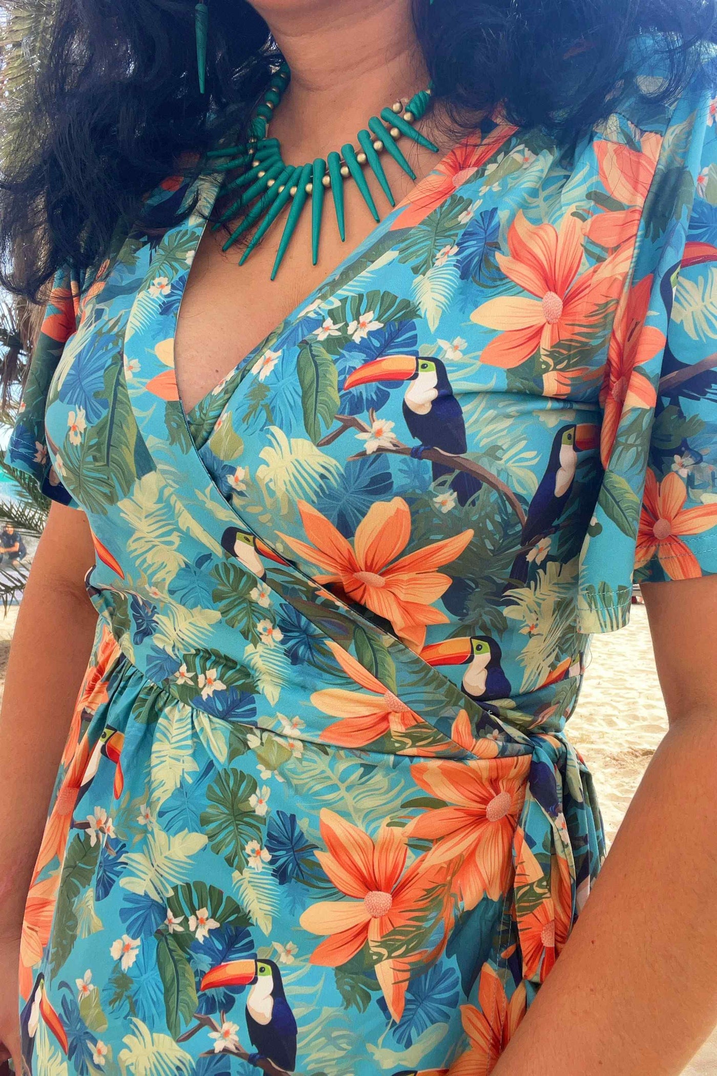 Close up view of a model wearing an Isla Tiki Toucan Maxi Wrap Dress