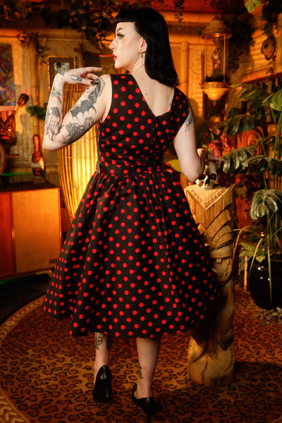 A model wearing a V-neck 50s Style Spot Dress in Black-Red