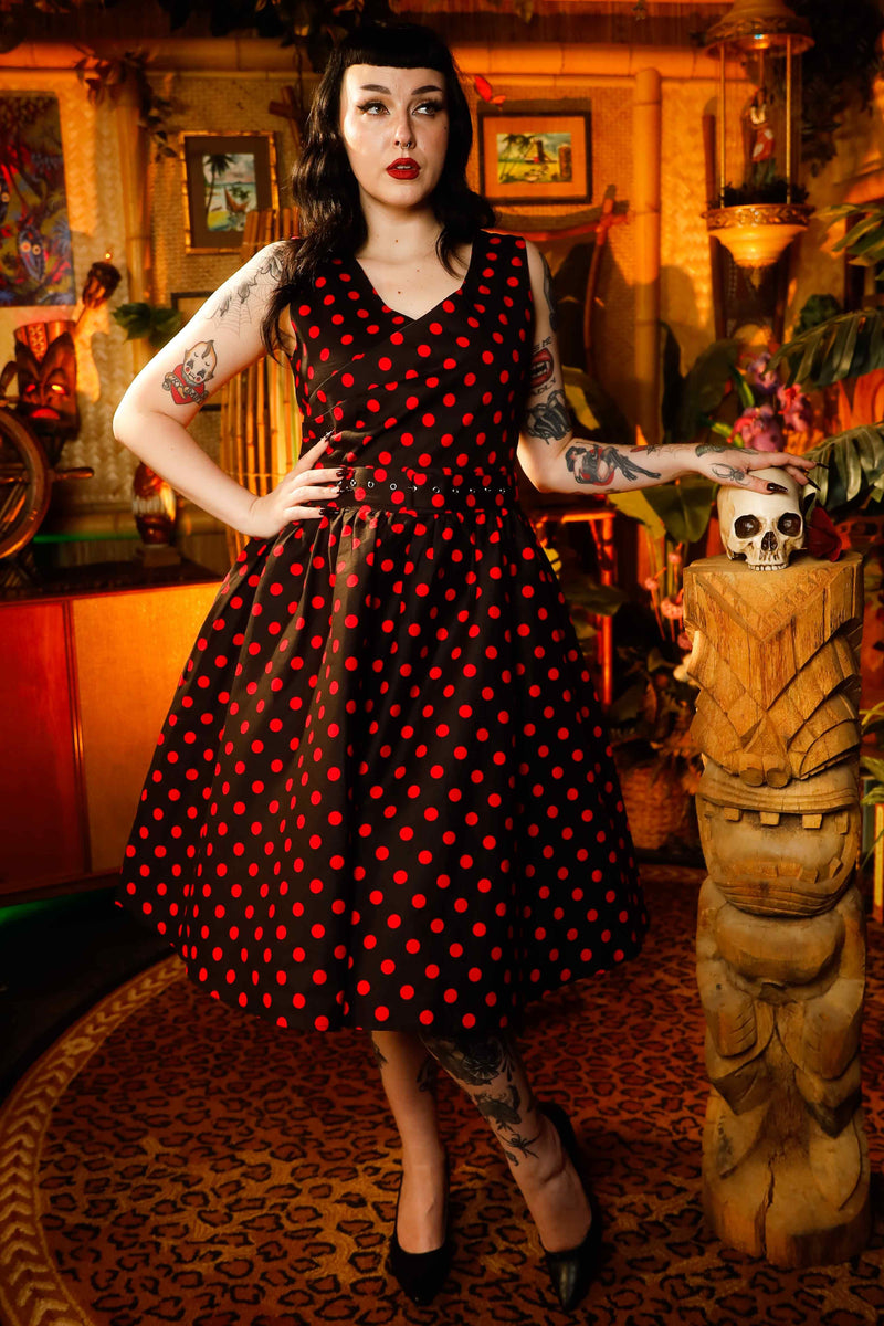 A model wearing a V-neck 50s Style Spot Dress in Black-Red