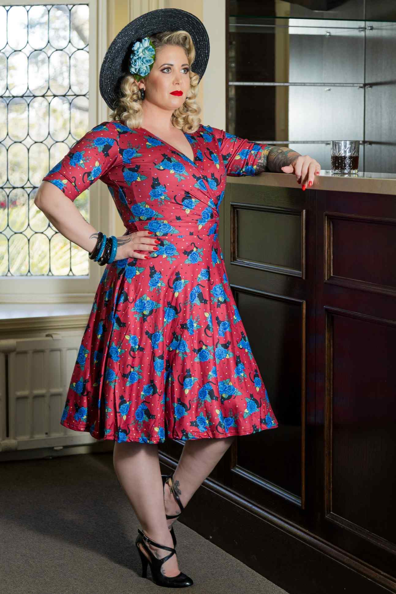 A lady wearing a Matilda Vintage Black Cat & Rose  Wrap Dress In Red