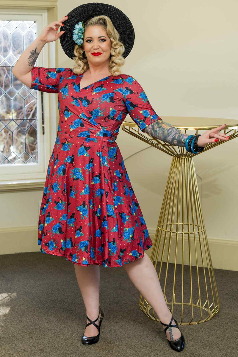A model wearing a Matilda Vintage Black Cat & Rose  Wrap Dress In Red