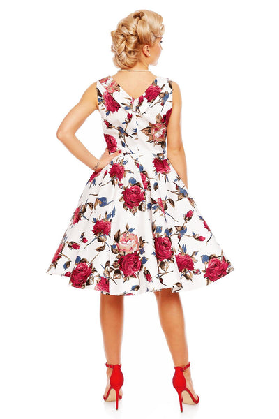 Model wearing Grace pleated bust dress, in white, with red roses, back view