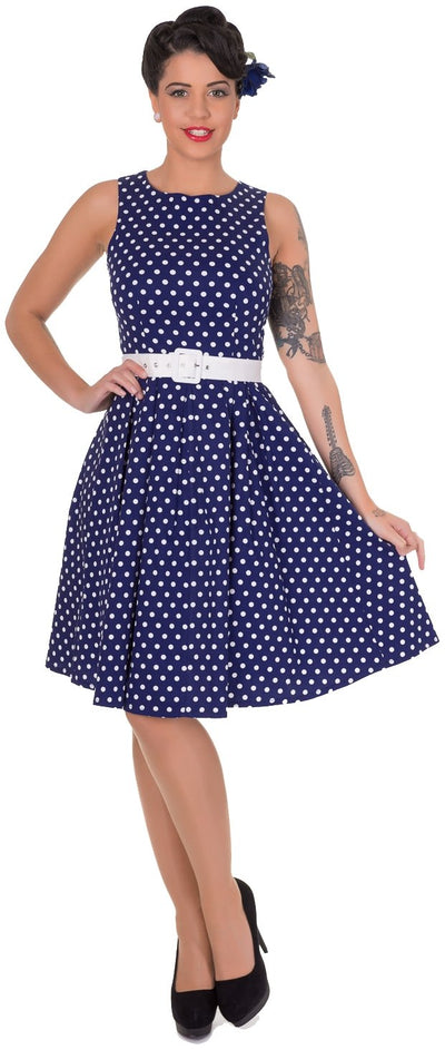 Model wearing our Lola sleeveless dress, in dark blue and polka dots, front view