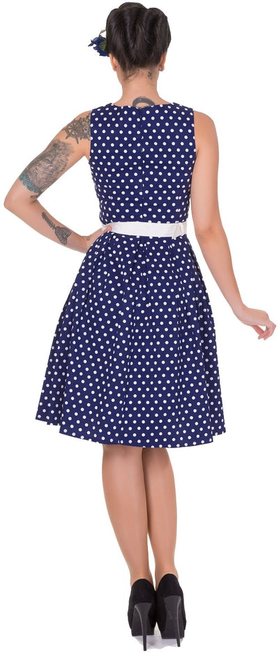 Model wearing our Lola sleeveless dress, in dark blue and polka dots, back view