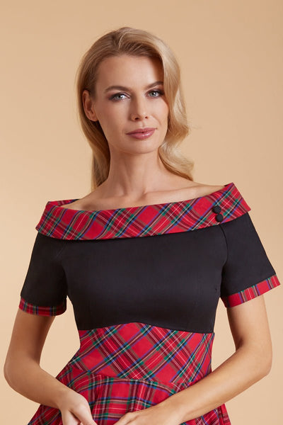 Model wears our bateau, short sleeved swing dress, in black and red tartan print, top view