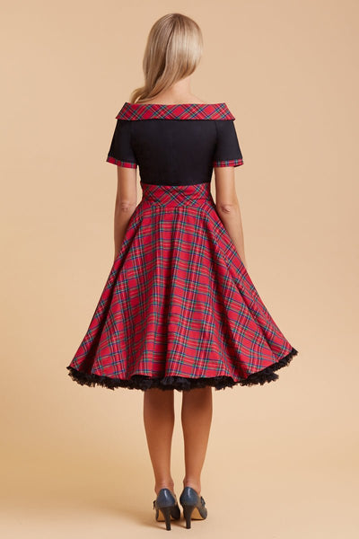 Model wears our bateau, short sleeved swing dress, in black and red tartan print, back view
