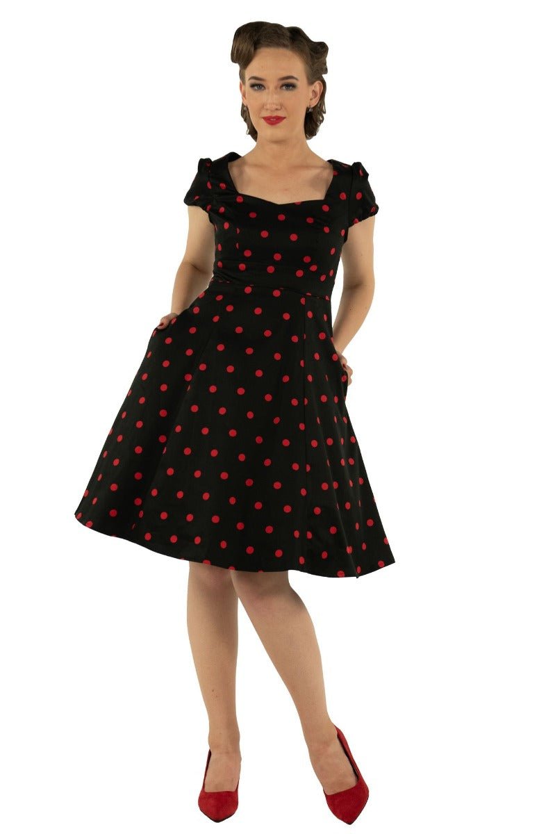 Model wears the Claudia cap sleeve dress in black, with red polka dots, front view