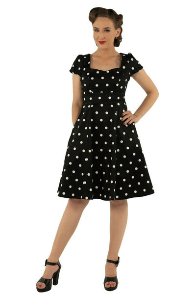 Model wears the Claudia short sleeve dress, in black, with white polka dots, front view