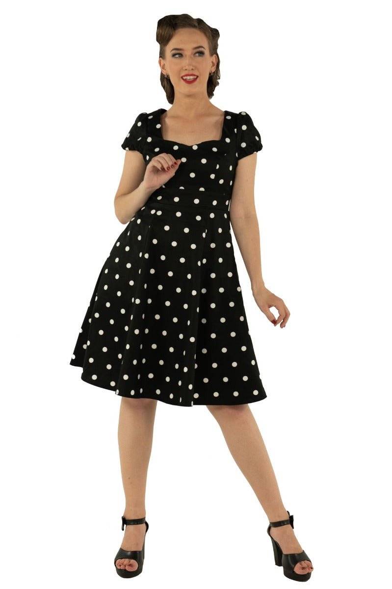 Model wears the Claudia short sleeve dress, in black, with white polka dots, front view