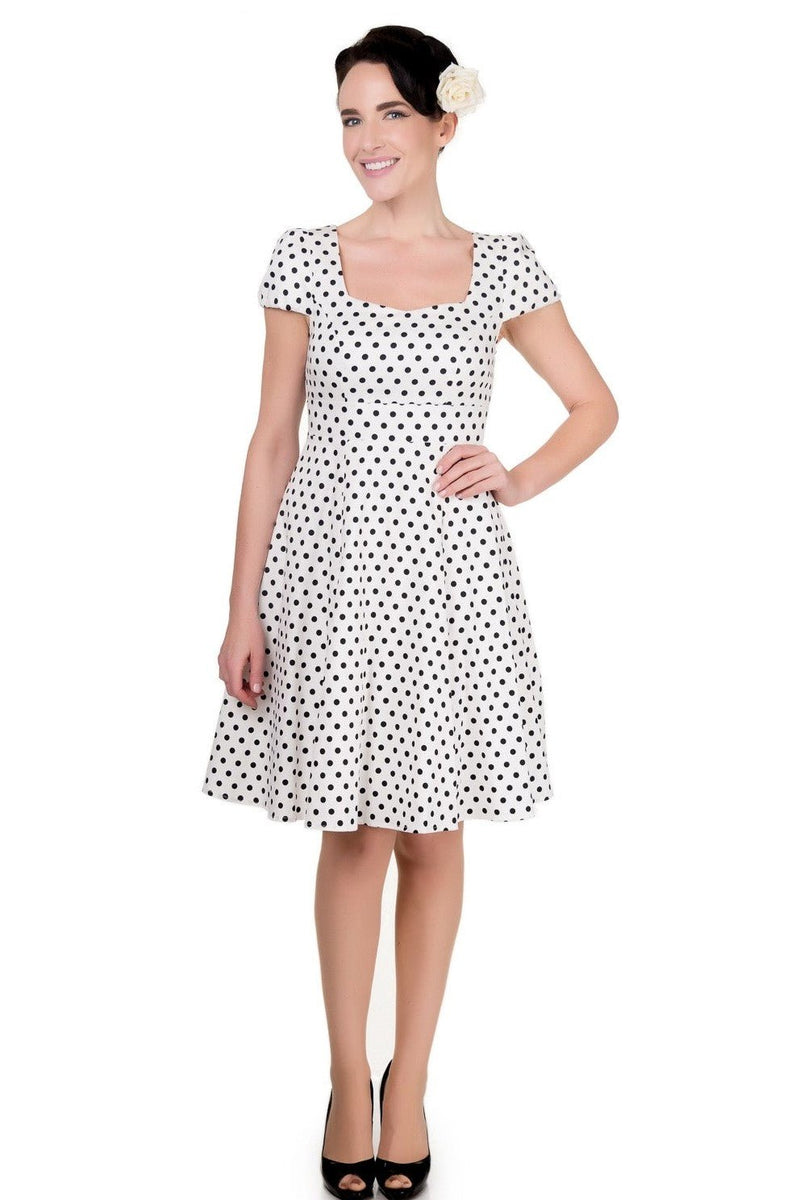 Model wearing white dress with black polka dots