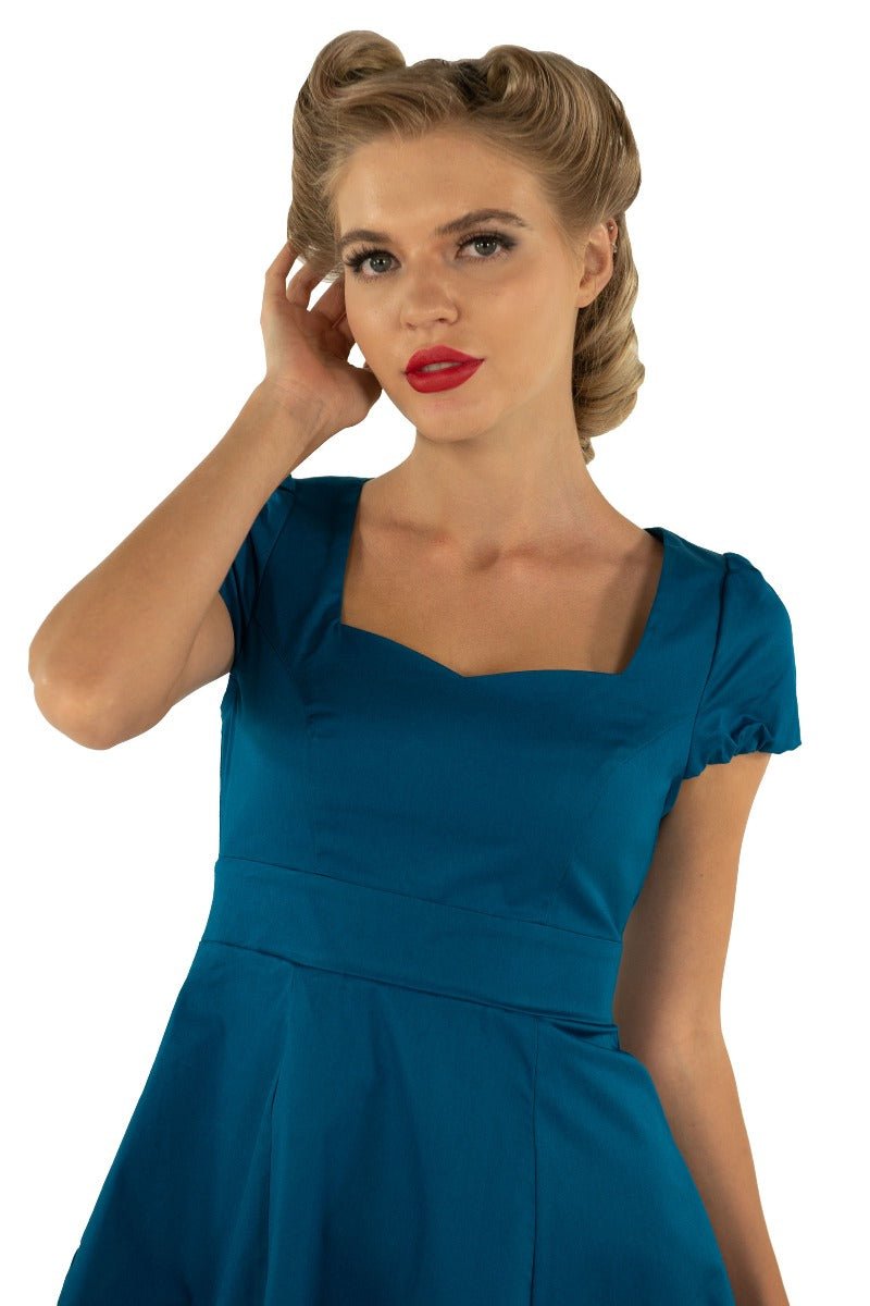 Model wearing plain teal blue 50's dress close up
