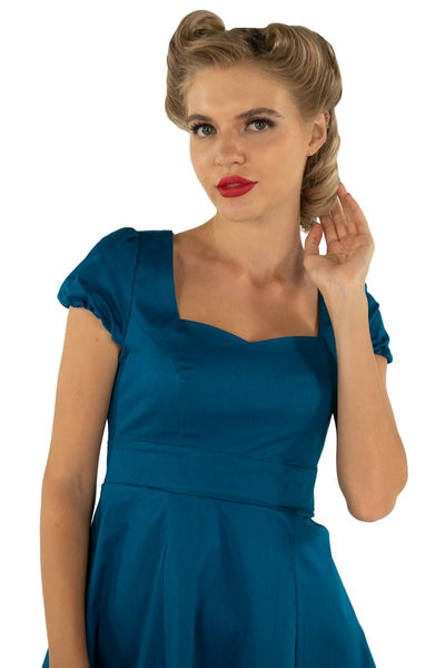 Model wearing plain teal blue 50's dress