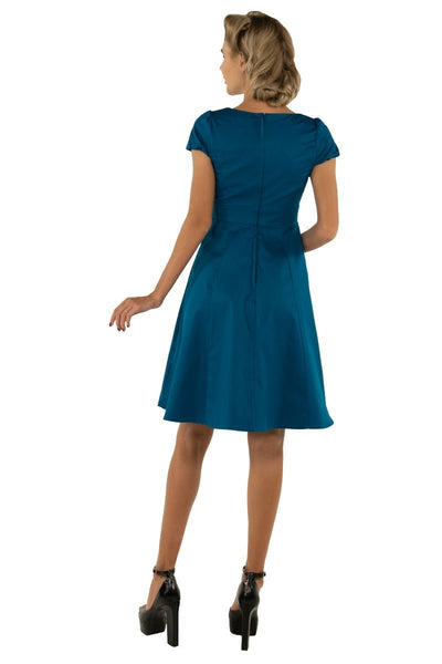 Model wearing plain teal blue 50's dress back view