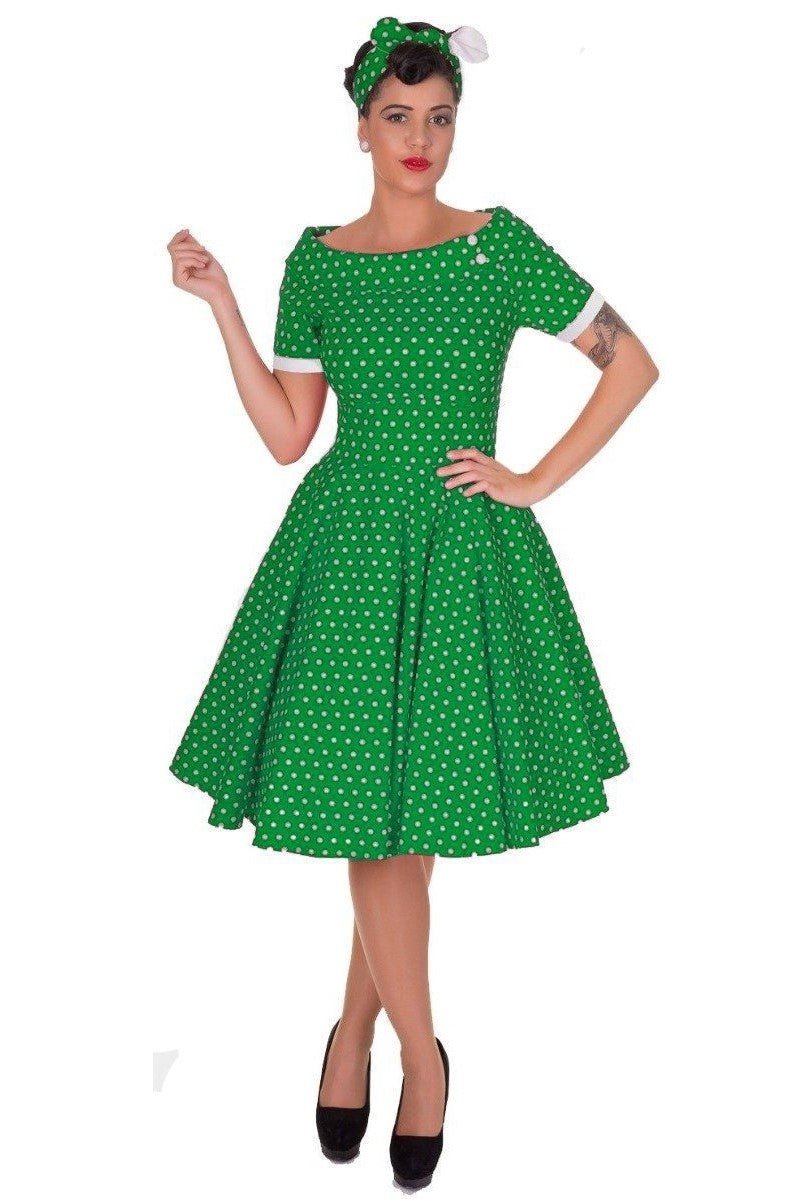 Model wears our dark green bateau neck dress, in polka dot print, front view