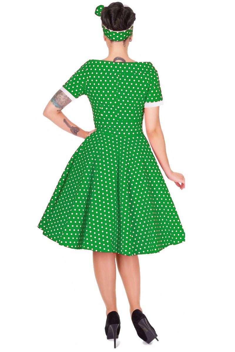 Model wears our dark green bateau neck dress, in polka dot print, back view