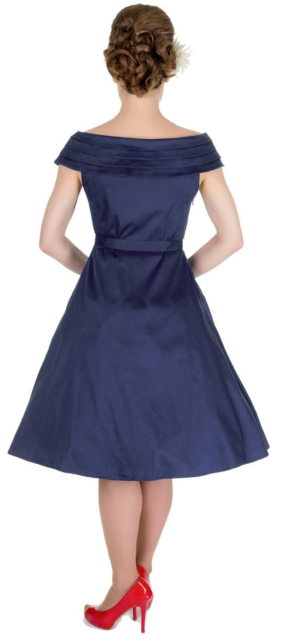 Model wearing our Marcia rockabilly dress, with boat neck, in navy blue, back view