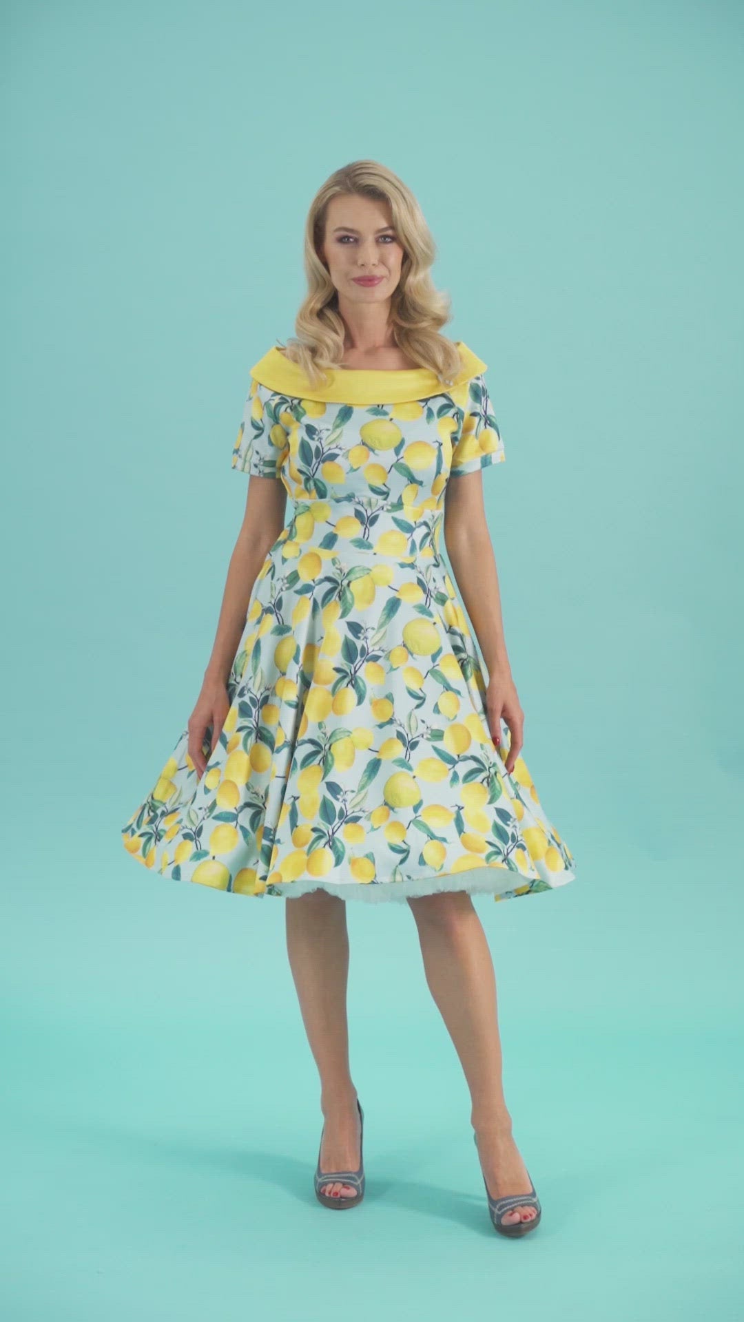 Model twirling in the blue/yellow lemon print Darlene dress