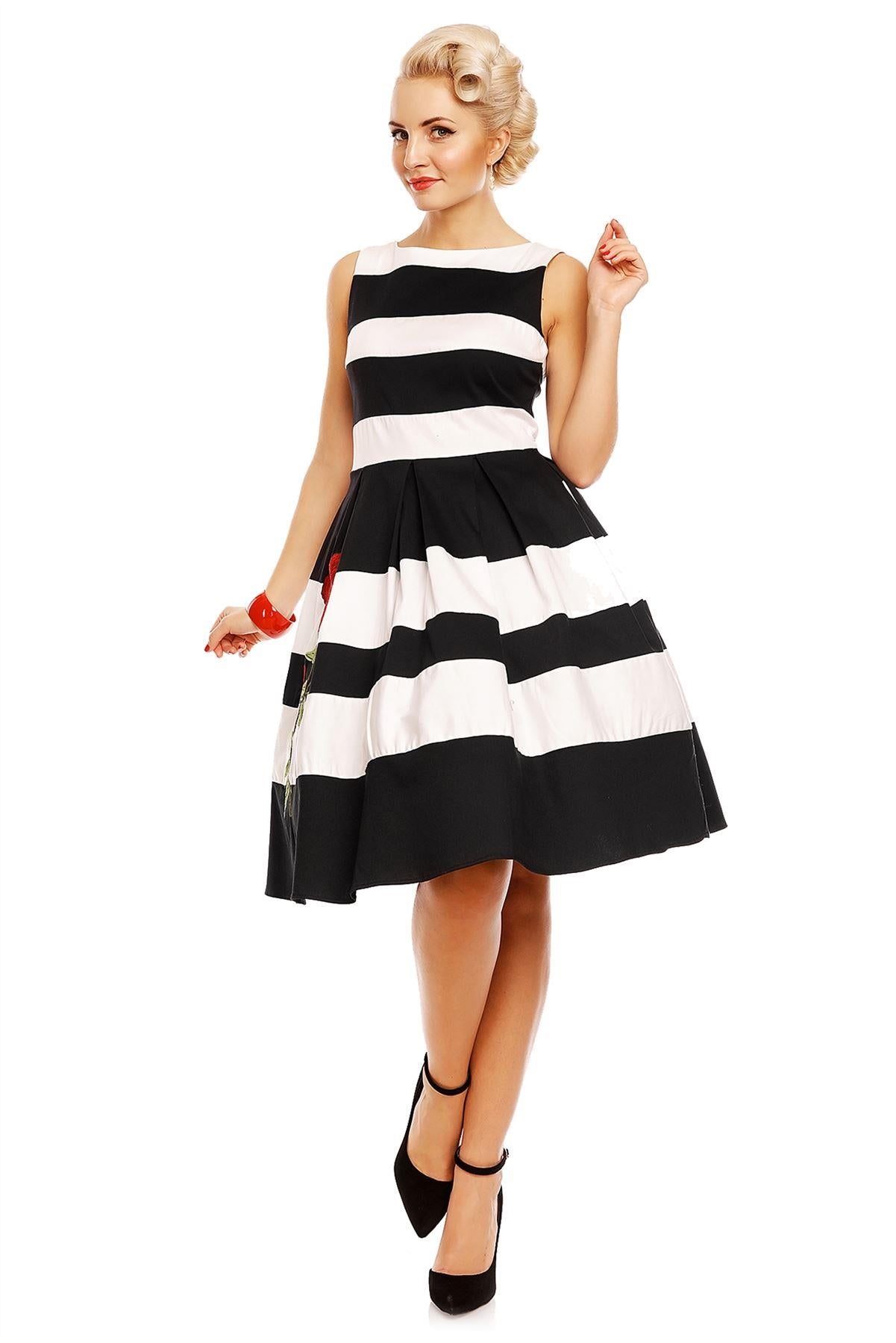 Model wears the black and white striped Annie swing dress, with embroidered red rose on the skirt, front view